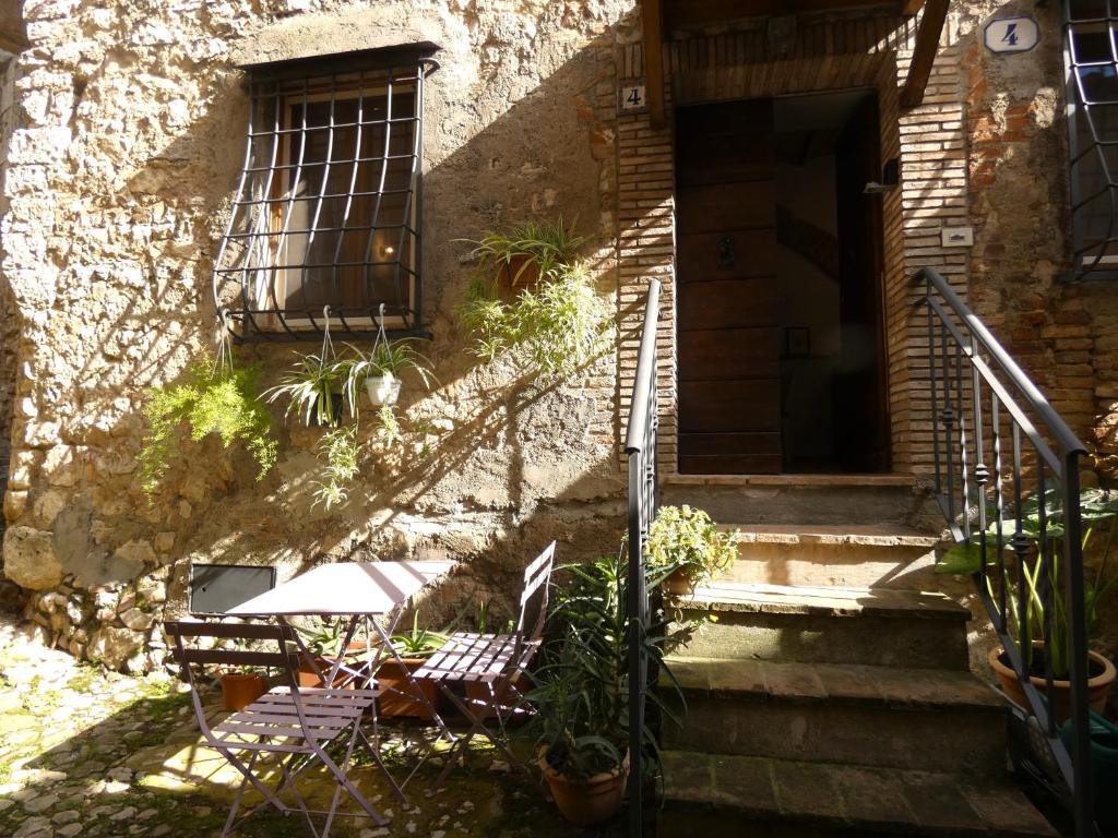 two chairs and a table in front of a building at SCAPPO IN UMBRIA, nel vicolo in Amelia