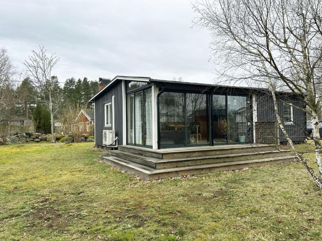 une petite maison avec des portes en verre sur une cour dans l'établissement Nice cottage located in Sandvik, 100 meters from a bay, à Hagby