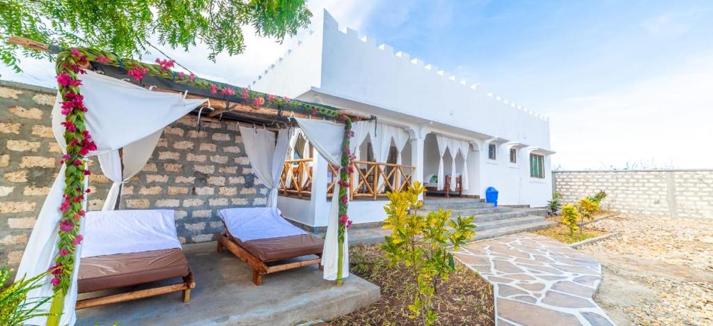 a house with two beds and a tent at Villa Clarida in Watamu