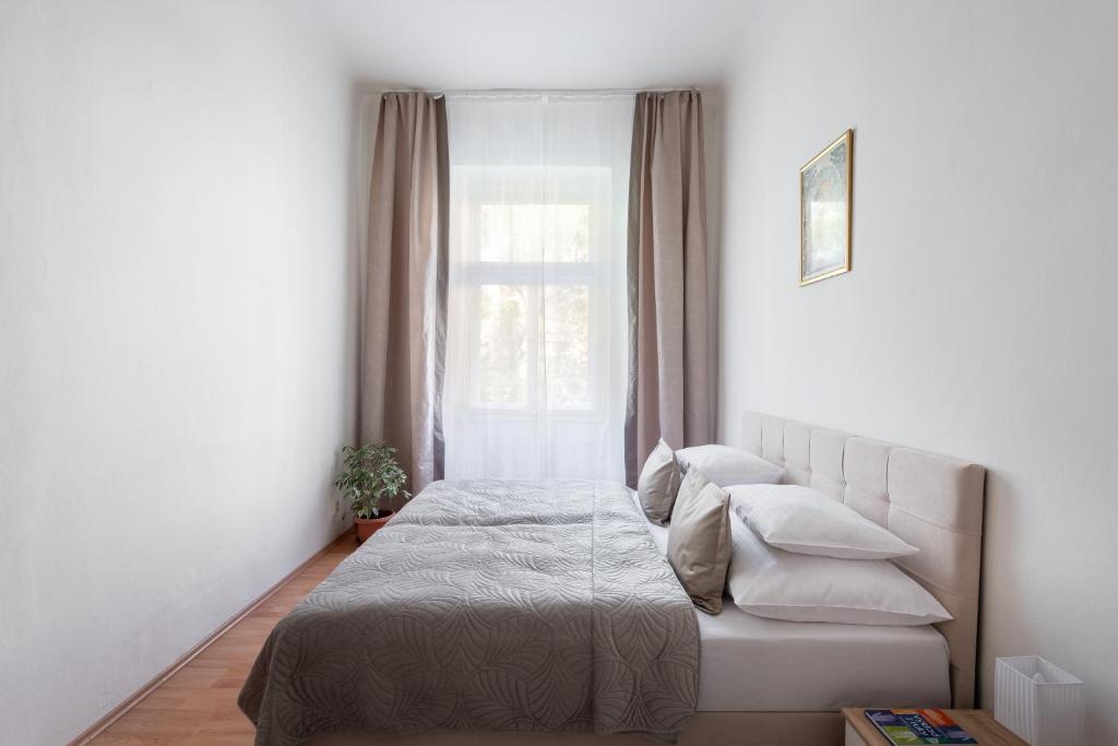 Habitación pequeña con cama y ventana en Prague - Karlin Apartments, en Praga