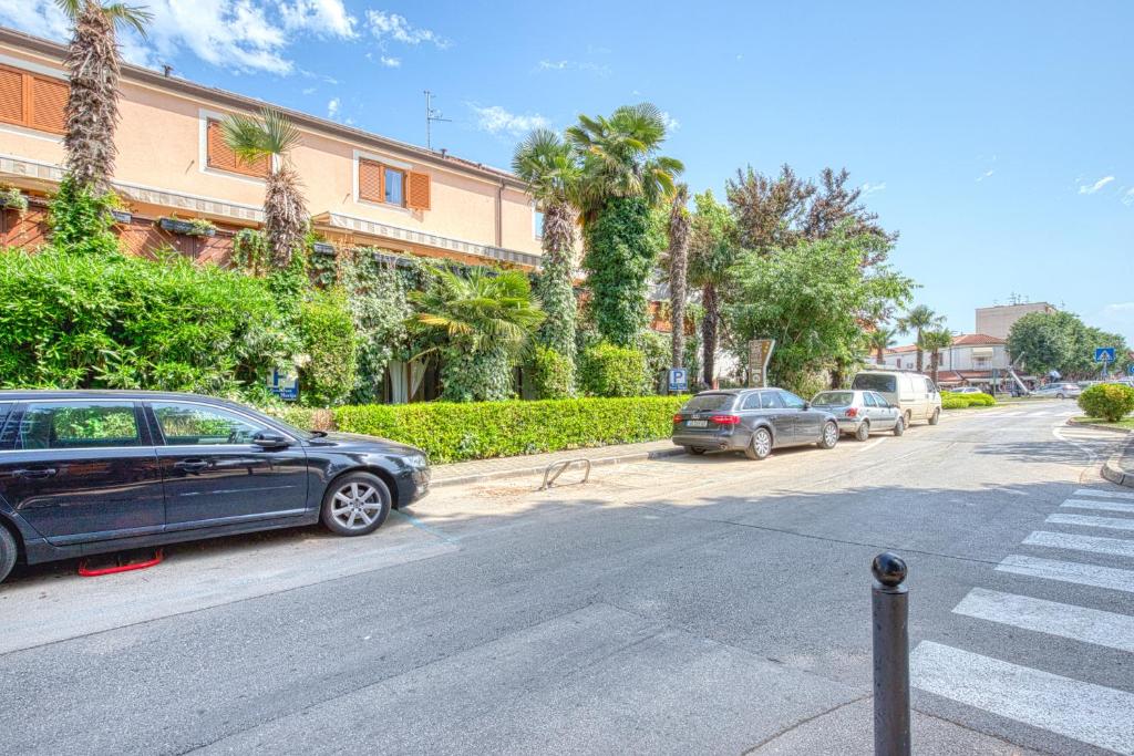 a group of cars parked on the side of a street at Pansion Comfort Santa Marija in Novigrad Istria