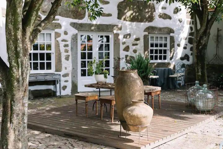 a patio with a table and a vase in front of a building at Casa da Pedra Cavalgada in Braga