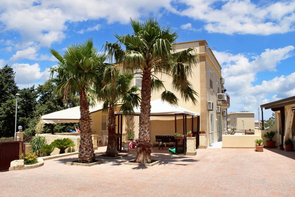 two palm trees in front of a building at Studio with sea view furnished balcony and wifi at Marsala 1 km away from the beach in Marsala
