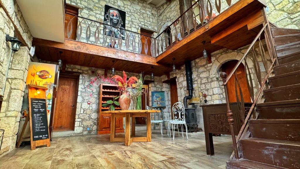 a large room with a wooden table and a staircase at Mahzen by d'Azur in Alacati