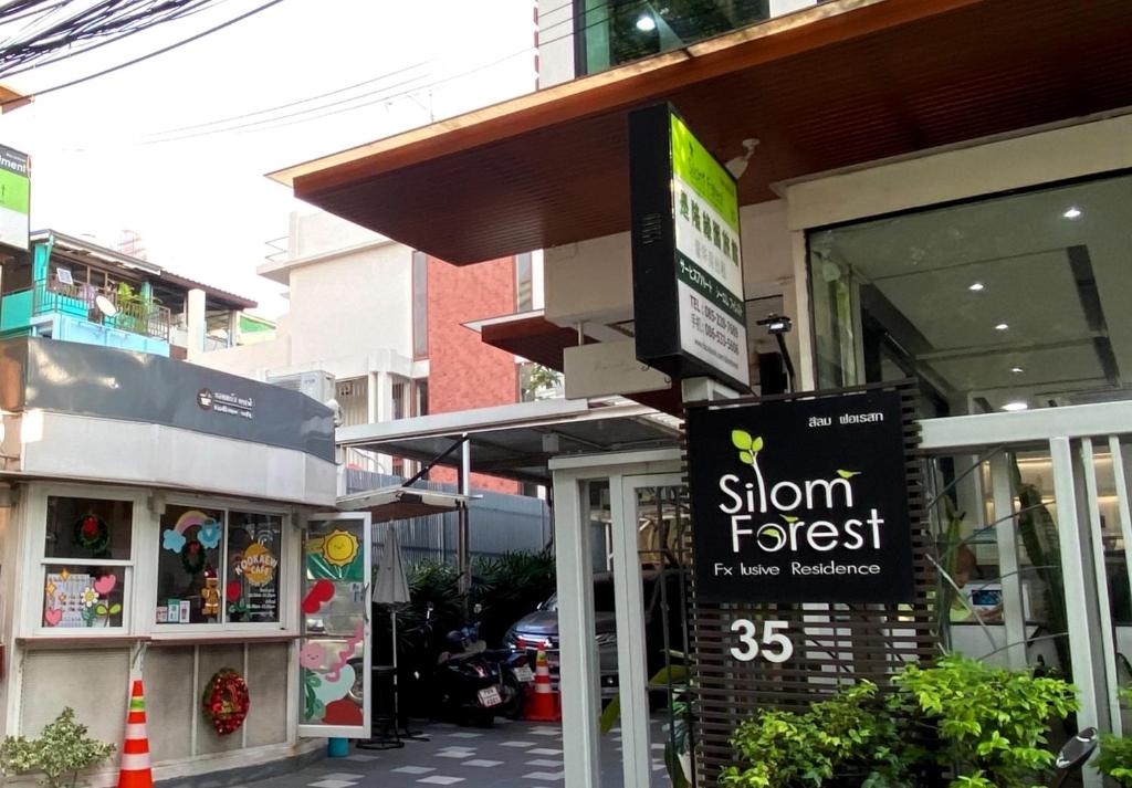 einen Laden mit einem Schild vor einem Laden in der Unterkunft Silom Forest Exclusive Residence in Bangkok