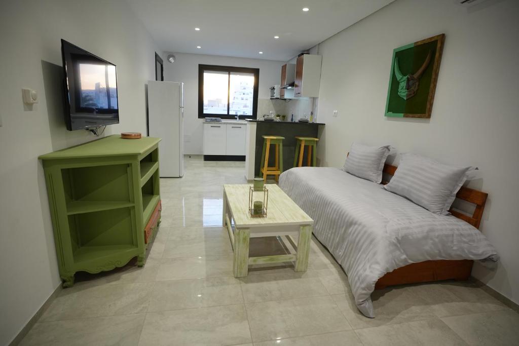 a bedroom with a bed and a table and a kitchen at L'horizon 5 in Sfax