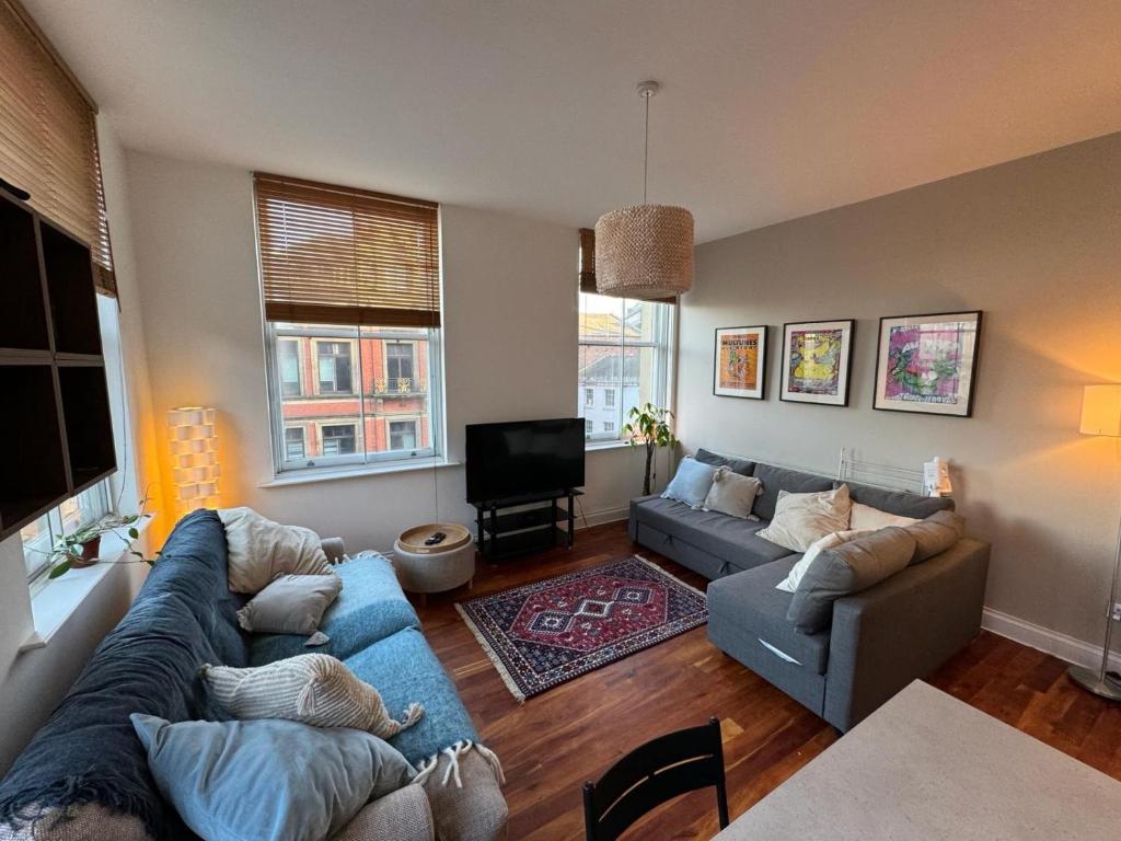 a living room with two couches and a tv at City Centre Apartment Liverpool in Liverpool