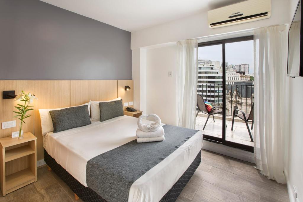une chambre d'hôtel avec un lit et une grande fenêtre dans l'établissement Hotel Sheltown, à Buenos Aires
