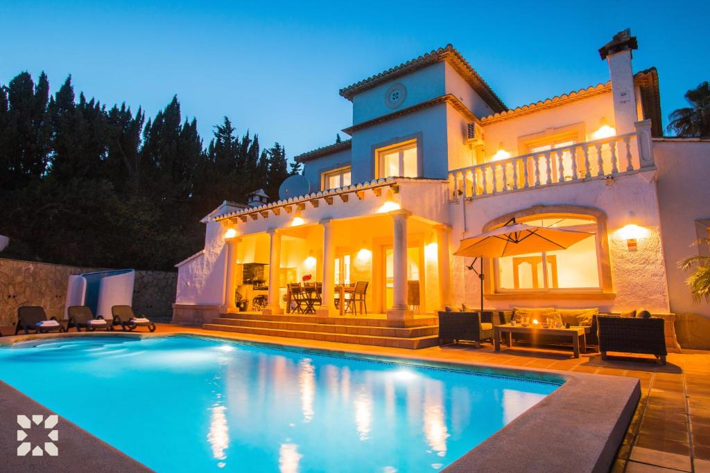 Villa con piscina frente a una casa en Villa Nasau by Abahana Villas, en Moraira