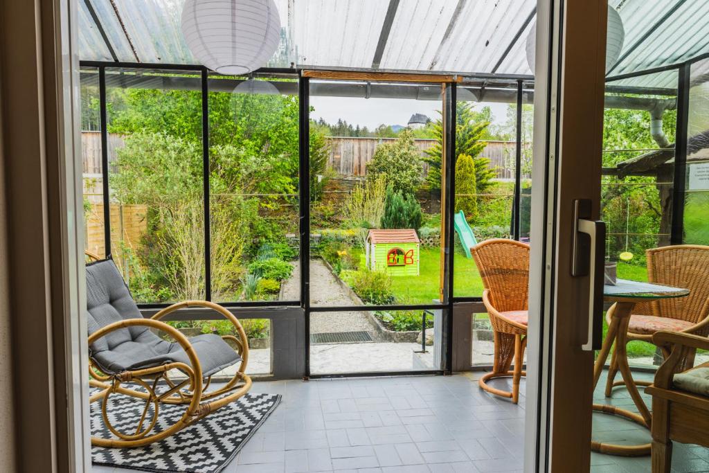 Habitación con puertas y sillas de cristal y mesa. en Ferienhaus am Staufeneck, en Piding