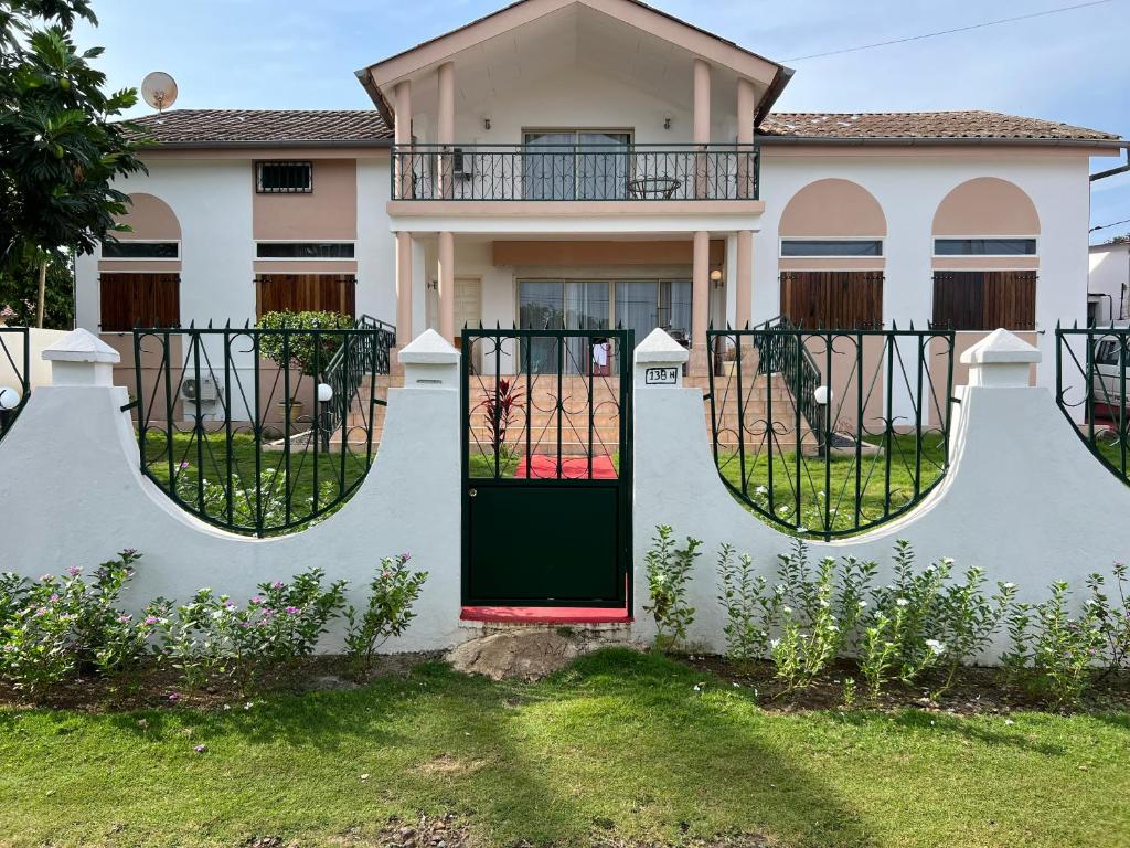 聖多美的住宿－Résidence Gabrielle，一座带绿门和围栏的房子