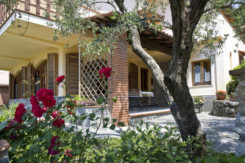 uma casa com flores vermelhas no quintal da frente em Casa Vacanze Colline di Luni em Castelnuovo Magra