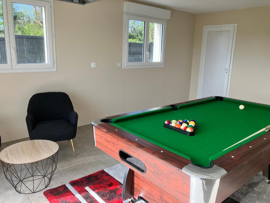 - un salon avec une table de billard et une chaise dans l'établissement Au pied des batteries, à Longues-sur-Mer