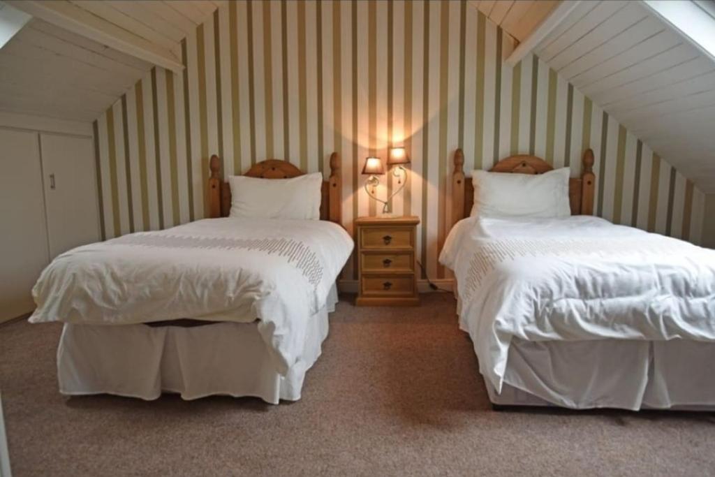 a bedroom with two beds with white comforters at Mardan House B&B in Killybegs