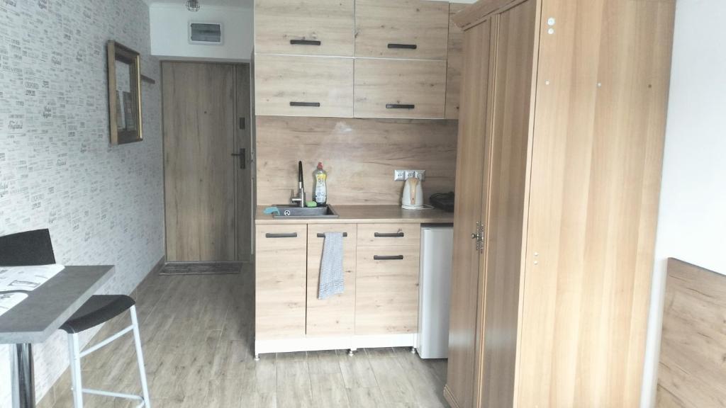 a kitchen with wooden cabinets and a counter top at NightHost Robotnicza 32 m 328 Wrocław in Wrocław