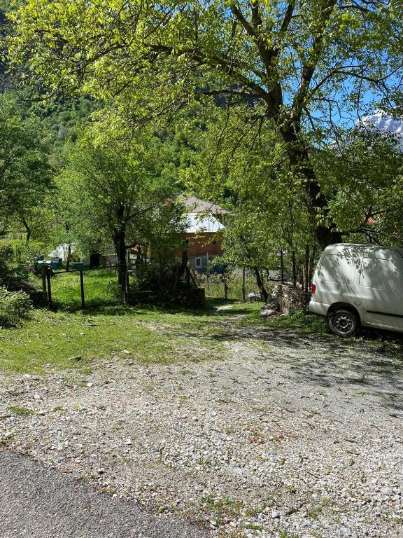 a van parked in a yard next to a house at Guesthouse Sibora in Valbonë