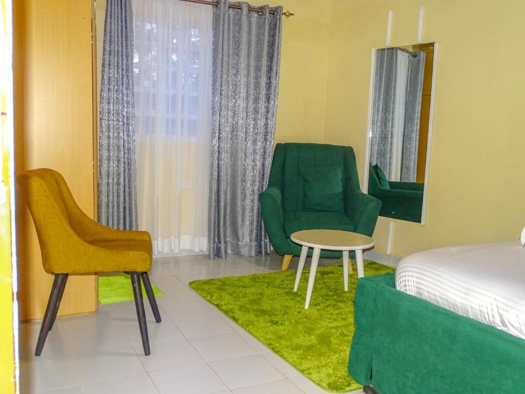 - une chambre avec un lit, deux chaises et une table dans l'établissement Nash Issah Green- Milimani Nakuru-1Bedroom, à Nakuru