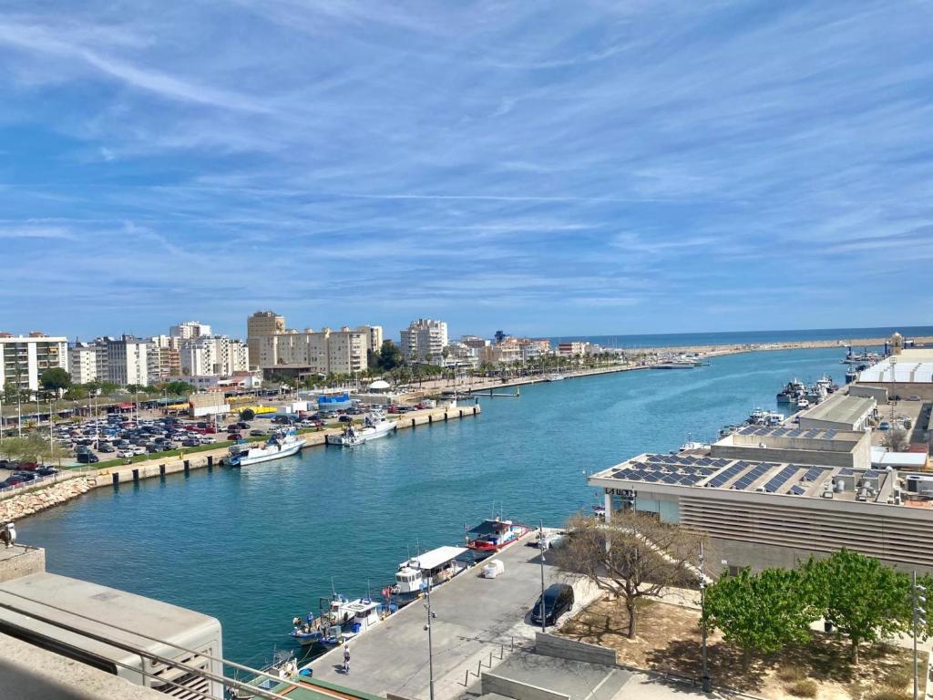 a view of a river with boats in a city at Plaza Mediterránea in Gandía