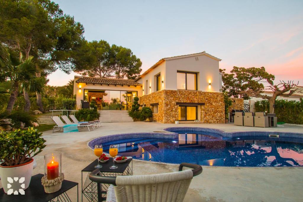 une villa avec une piscine en face d'une maison dans l'établissement Villa Los Roques by Abahana Villas, à Benissa