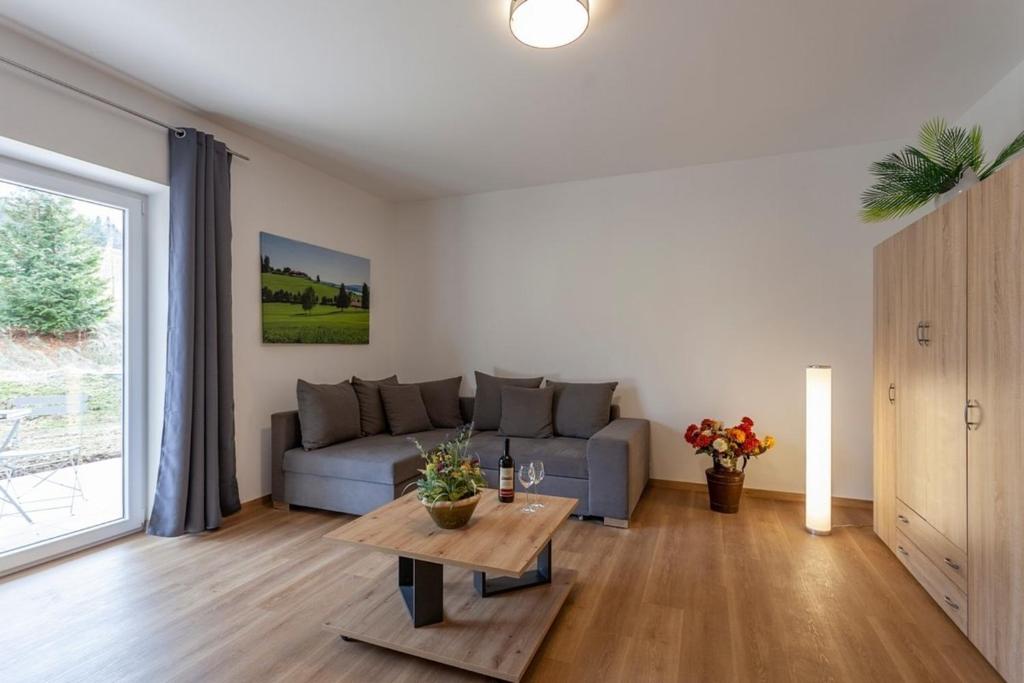 sala de estar con sofá y mesa en Ferienwohnung 8, en Lechbruck