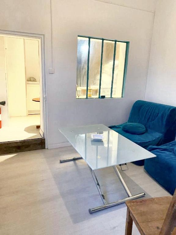 Le Chêne的住宿－Studio avec jardin amenage et wifi a Le Chene，客厅配有蓝色的沙发和玻璃桌