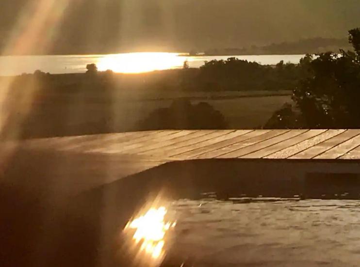 uma vista para o pôr-do-sol a partir do telhado de uma casa em Villa Pierre SANTONI em Porticcio