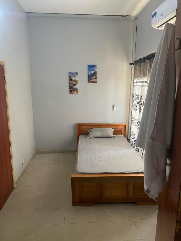 a small bedroom with a bed and a window at Estepona Playa Hostel in Accra