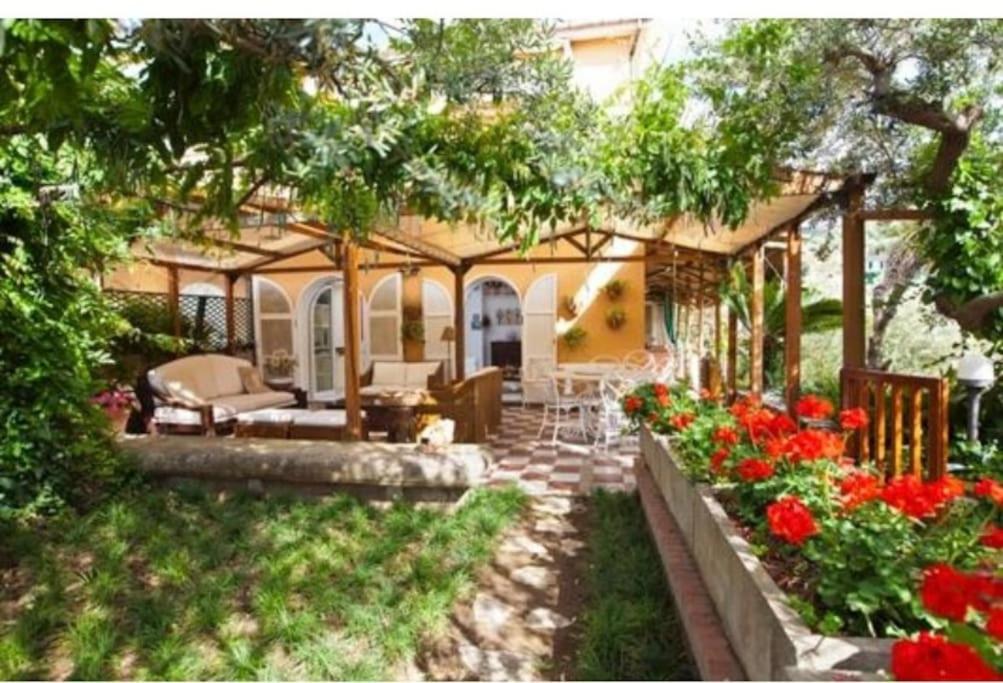 ein Haus mit einem Garten mit Blumen im Hof in der Unterkunft Villa Sofia in Massa Lubrense
