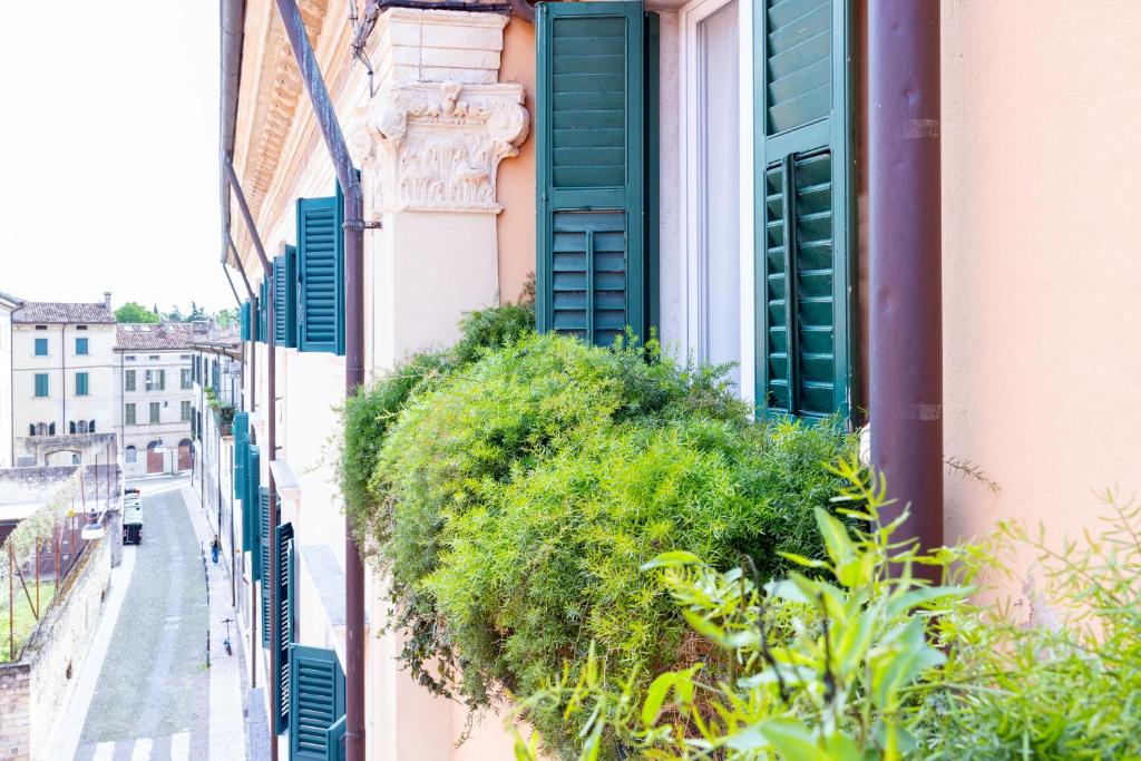 a window with green shutters on a building at Boutique Apartment Cà Monastero in Verona