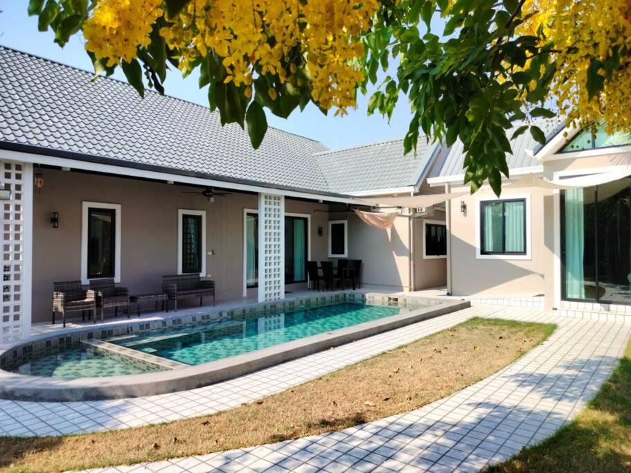 Villa con piscina frente a una casa en BRAND-NEW! The Private PoolVilla /4BR byน้องมังคุด, en Nong Prue