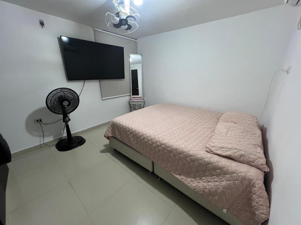 a bedroom with a bed and a flat screen tv at Apartamento festival vallenato in Valledupar