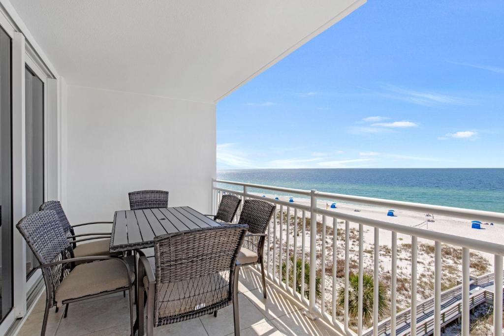 a balcony with a table and chairs and the ocean at FL-Seaspray Perdido Key 605 condo in Pensacola