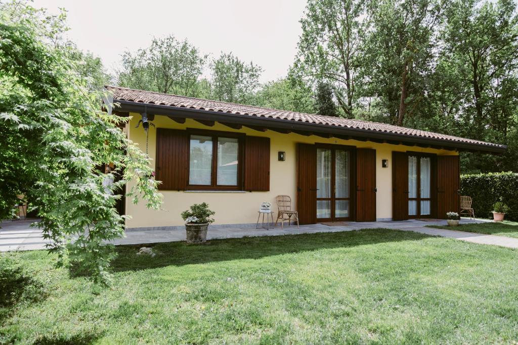 una pequeña casa blanca y amarilla con patio en LA CASETTA Malpensa Guesthouse en Case Nuove