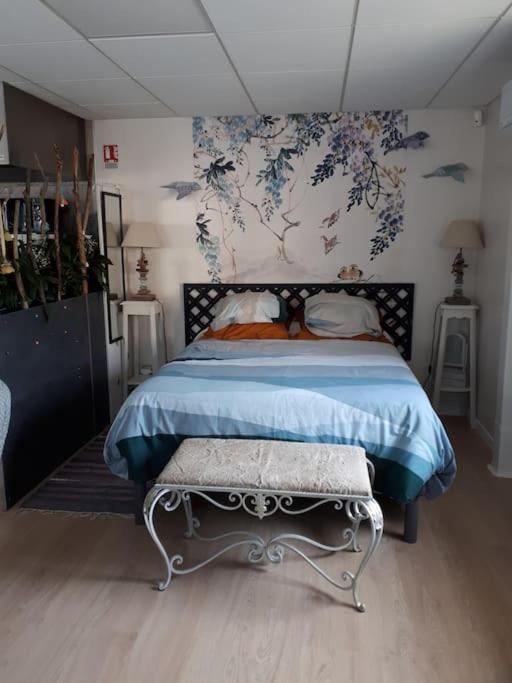 a bedroom with a bed with a blue bedspread at La Lusitanie in Morteau