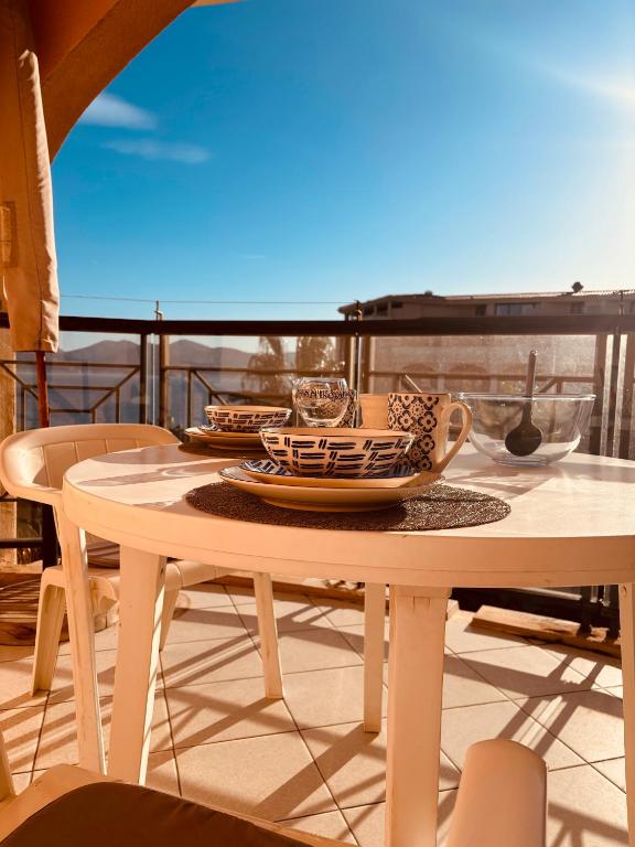 una mesa con platos y cuencos en el balcón en Résidence La Palme d'Azur - Petersen App 610, en Cannes