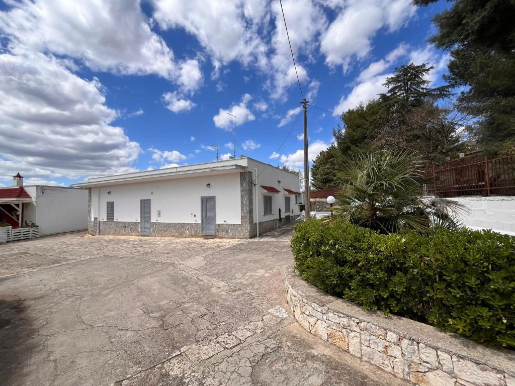 um edifício branco com uma entrada num parque de estacionamento em A casa di nonna Lina em Polignano a Mare