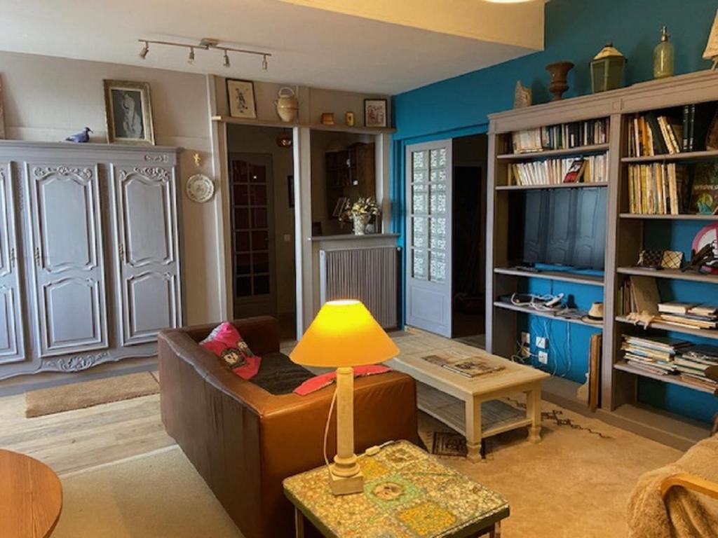 - un salon avec un canapé et une lampe sur une table dans l'établissement Les volets bleus, à Monflanquin