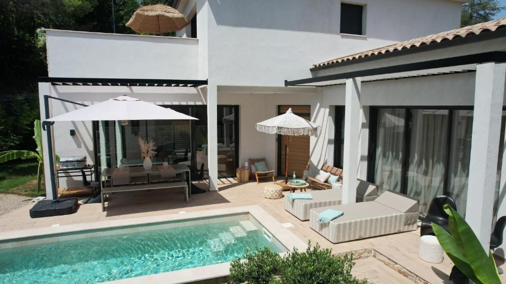 a villa with a swimming pool and a house at Superbe Villa très proche cannes in Mougins