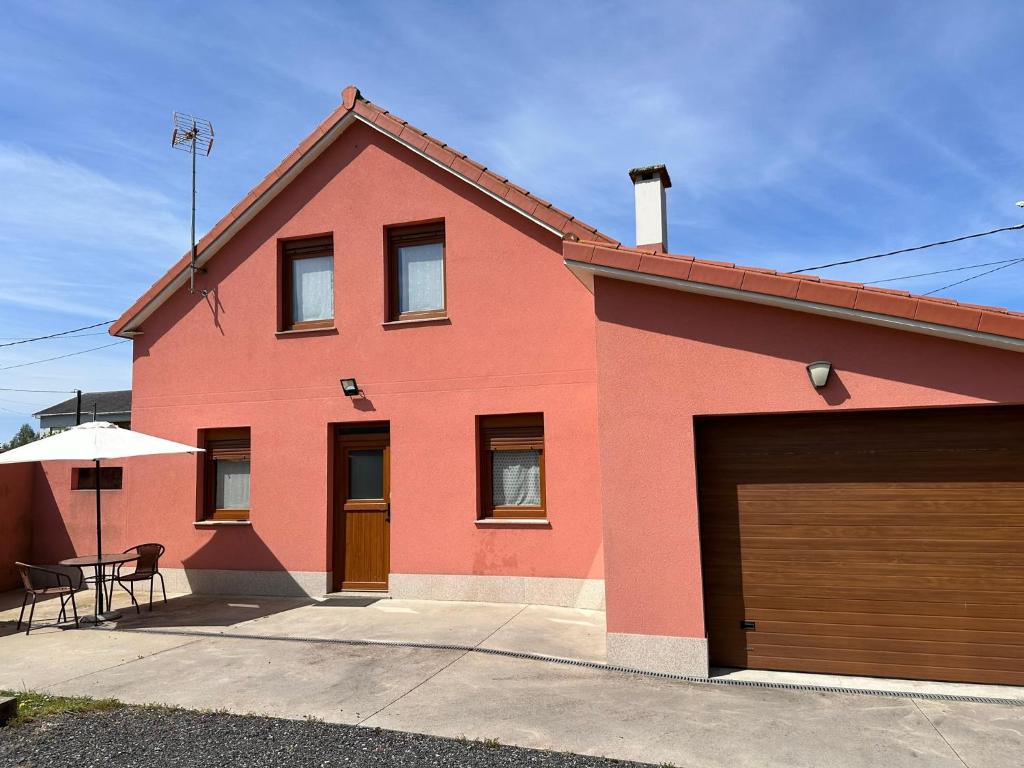una casa roja con garaje en Casa Bieiteiro, en Valdoviño