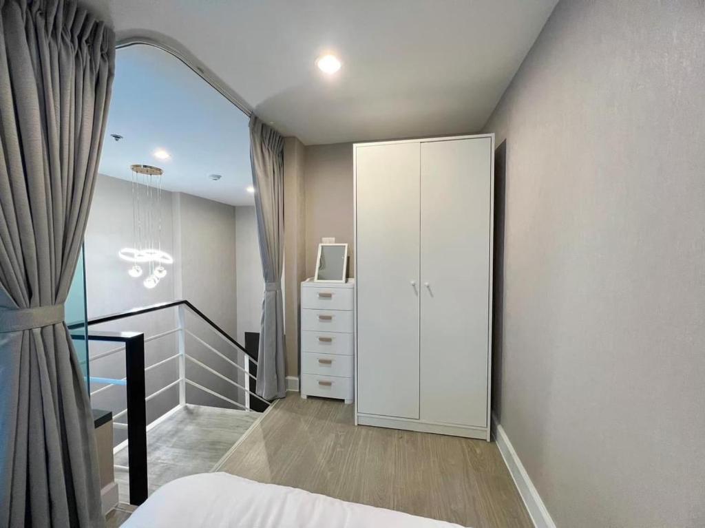 Bang SuにあるMetro sky prachachuenの白いキャビネットとバルコニー付きのベッドルーム1室
