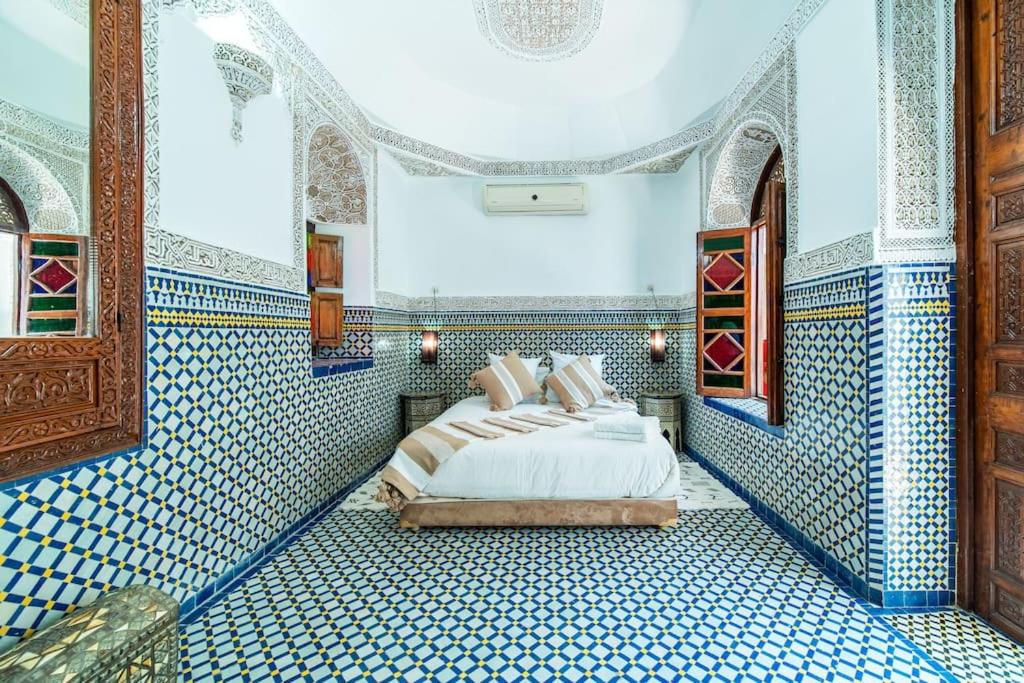 - une chambre avec des murs carrelés bleus et blancs et un lit dans l'établissement Riad Khadoj-Marrakech-Traditional, à Marrakech