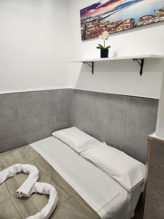ナポリにあるCasa Espositoの棚付きの部屋の小さなベッド1台