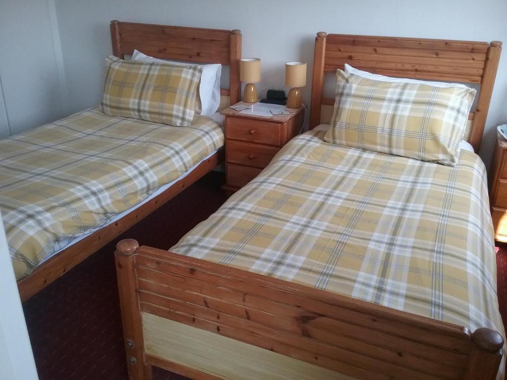 two beds sitting next to each other in a room at Fairways Guest House in Newquay