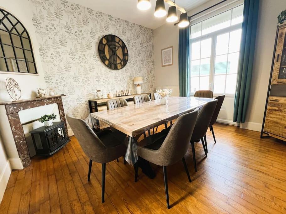 Un comedor con mesa y sillas de madera. en Villa Samson, en Le Tréport