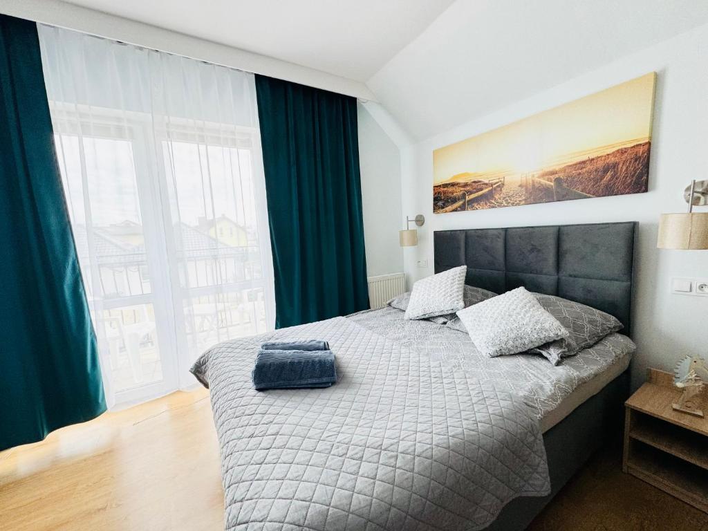 a bedroom with a bed with a blue bag on it at Złote Piaski Pensjonat z basenem in Darłowo