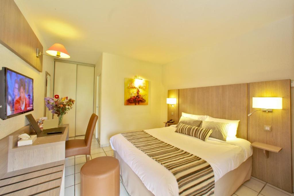 Pokój hotelowy z dużym łóżkiem i biurkiem w obiekcie Hostellerie du Causse w mieście Gramat