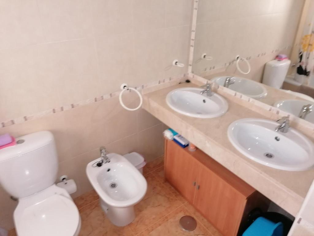 a bathroom with two sinks and a toilet at Lodosol in Lo Pagán