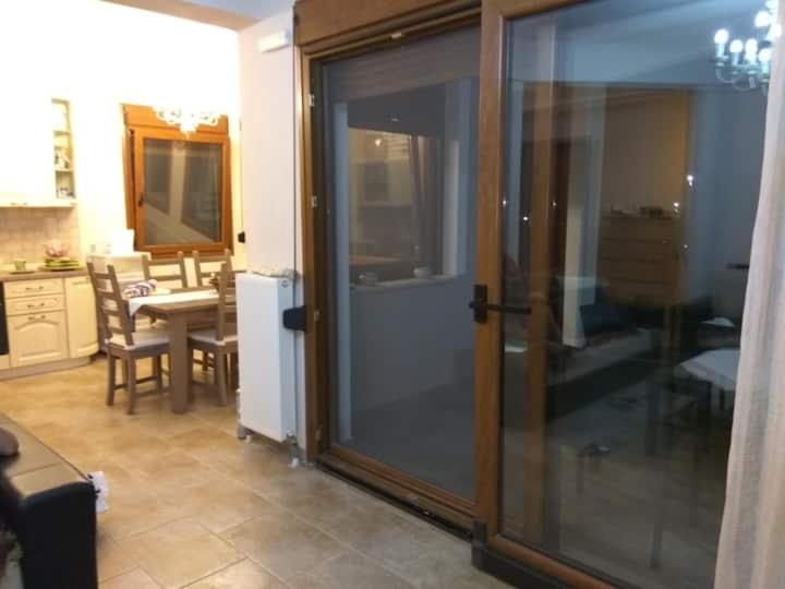 una puerta corredera de cristal en una cocina con mesa en Family friendly house nearby the sea, en Agia Paraskevi