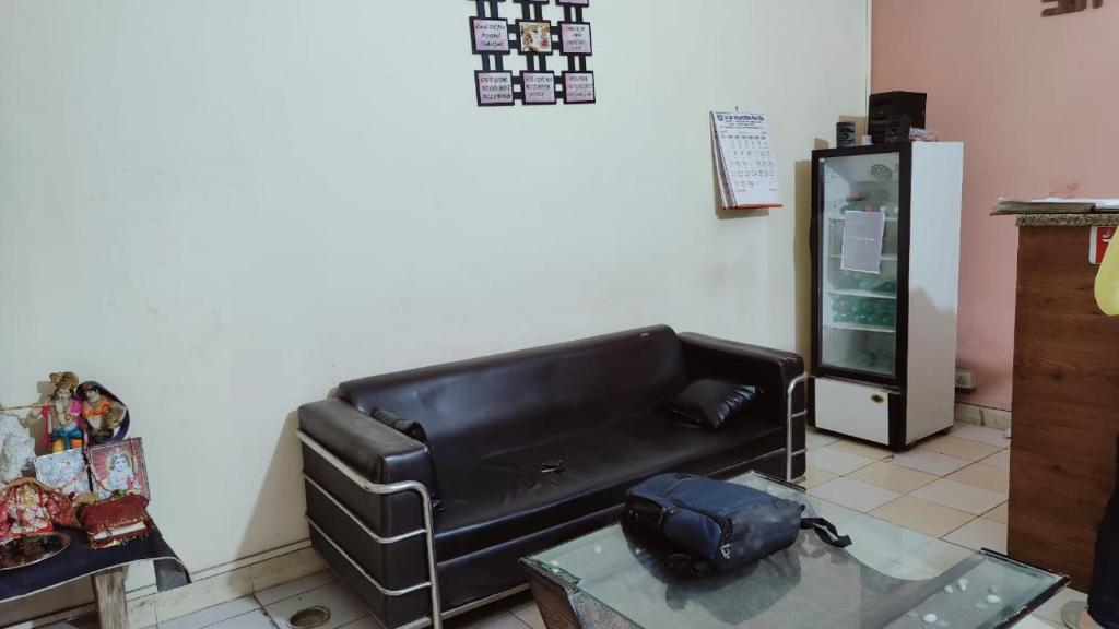 salon z czarną skórzaną kanapą i stołem w obiekcie Hotel AV Residency Sector 45 Noida w mieście Noida