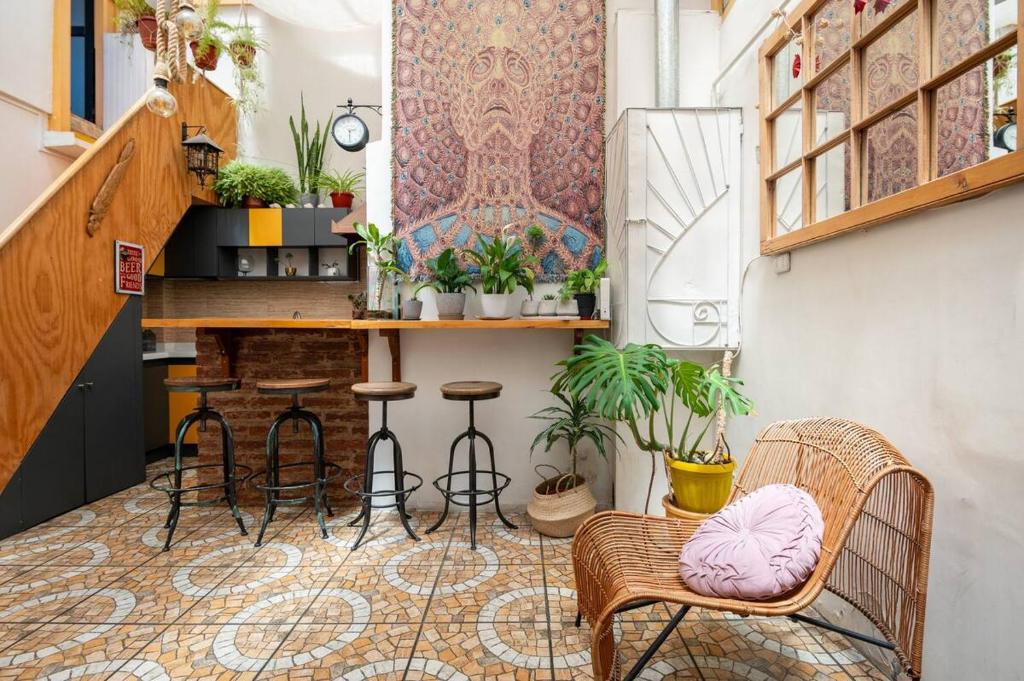 Habitación con bar con sillas y mesa. en Casa Fibonacci en Valparaíso